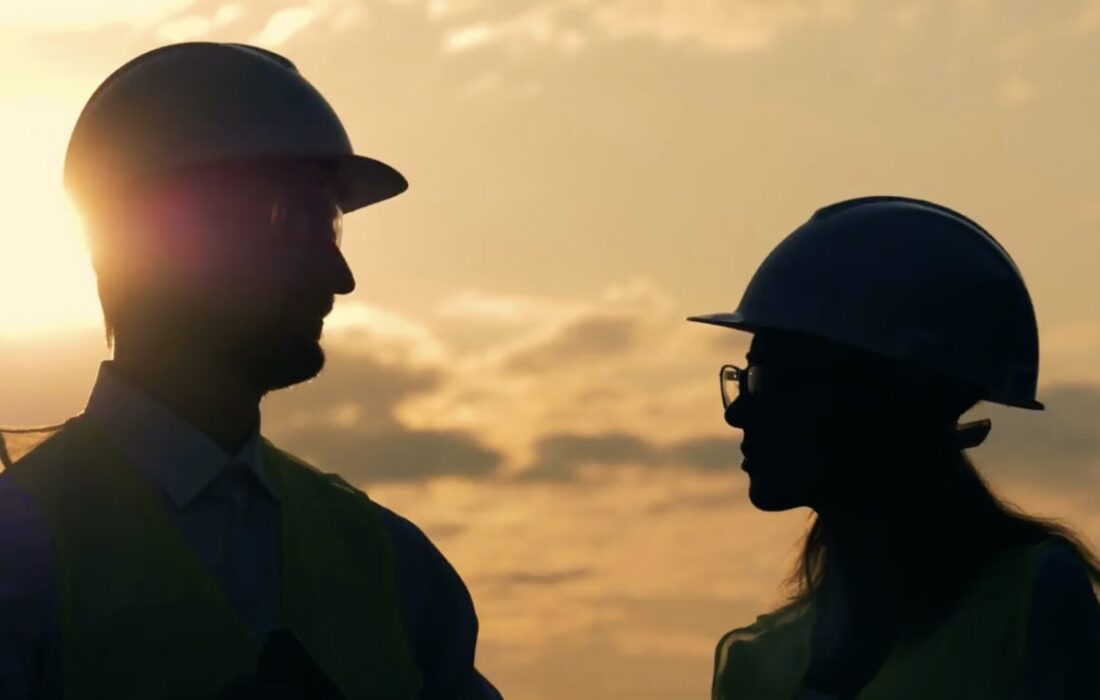 Two workers meeting outside at sunset